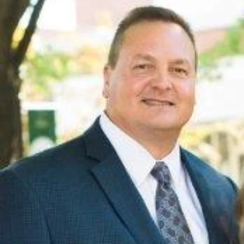 Man smiling wearing a suite and tie outside