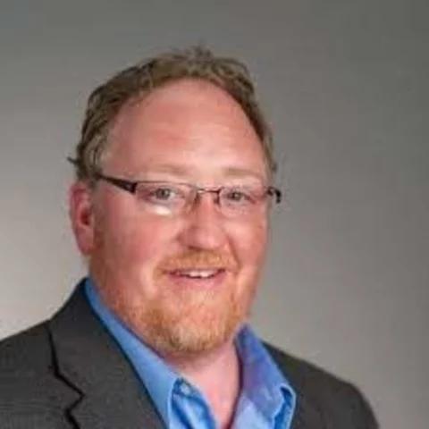 Man smiling wearing a suite and tie outside